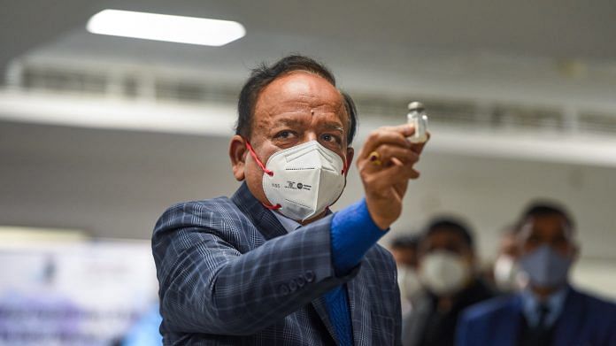 Health Minister Harsh Vardhan displays a Covishield vaccine vial at AIIMS in New Delhi on 16 January