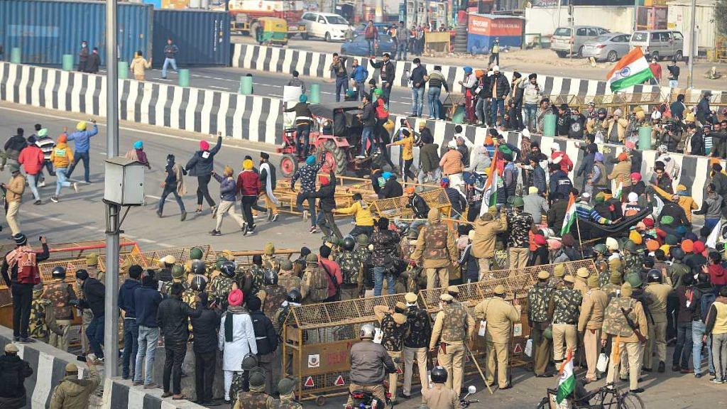 Farmers break through Delhi Police barricades at the Ghazipur border as they move towards Akshardham during their tractor rally on Republic Day in New Delhi, on 26 January 2021 | Vijay Verma | PTI