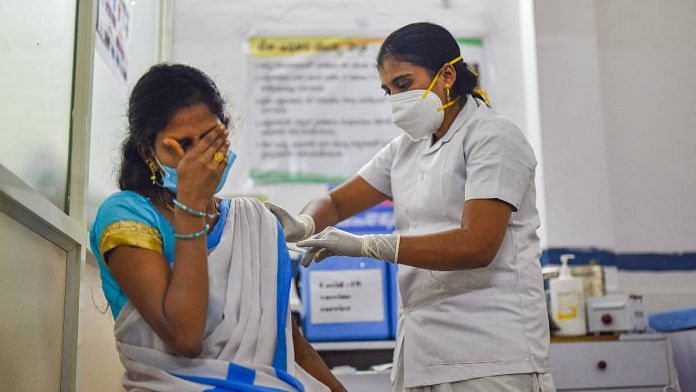 A medic administers the first vaccine dose to a frontline worker, after the virtual launch of Covid-19 vaccination drive by Prime Minister Narendra Modi, at a health center in Visakhapatnam on 16 January 2021 | PTI