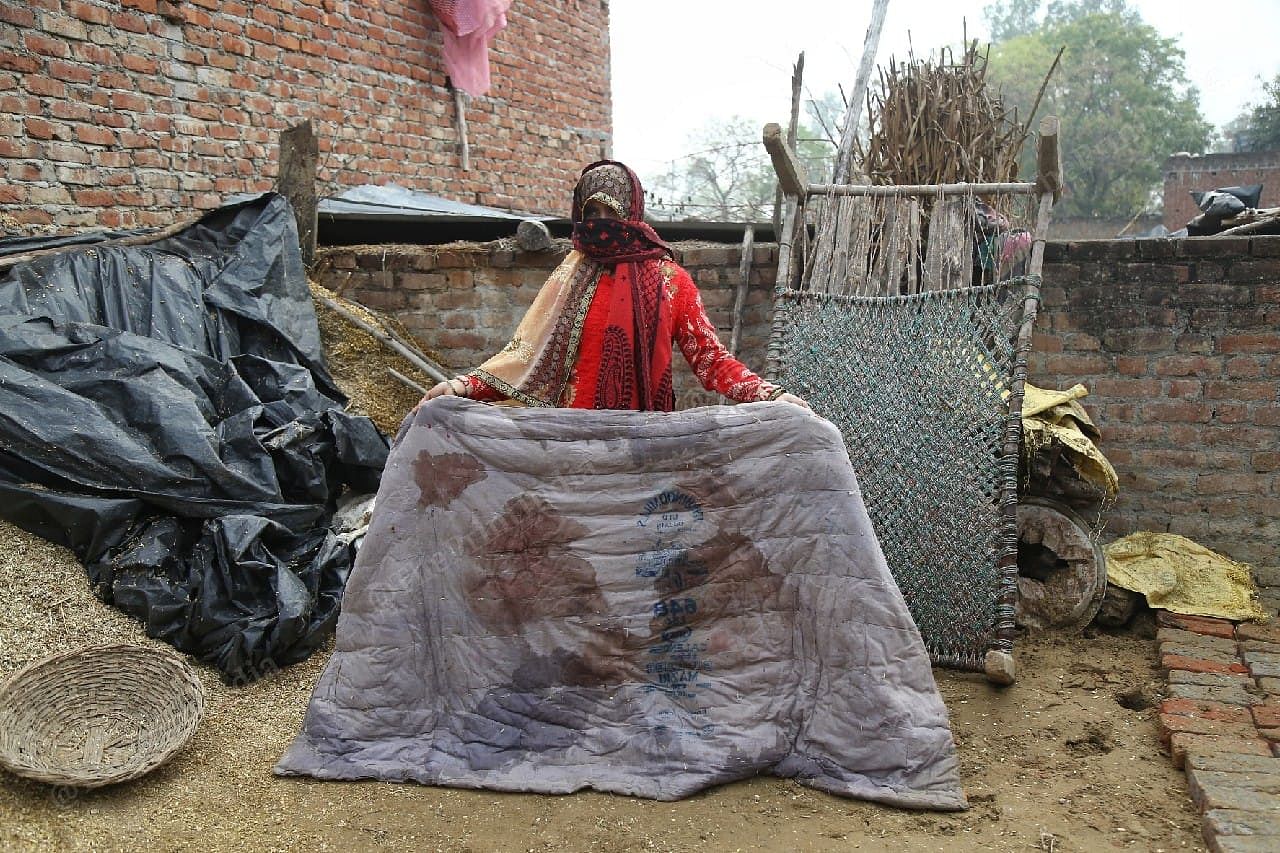 One of the victim's daughters shows the blood-soaked mattress on which she was brought home by the suspects | Suraj Singh Bisht | ThePrint