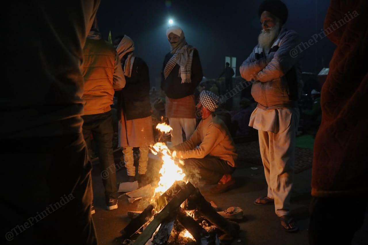 Farmers surround a bonfire at Ghazipur | Photo: Manisha Mondal | ThePrint