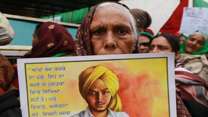 A protesting farmer holds up a Bhagat Singh poster at Singhu border earlier this month | Manisha Mondal | ThePrint