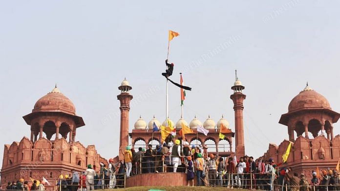 Farmers hoisting flags from the Red Fort rampart | Photo: Manisha Mondal | ThePrint