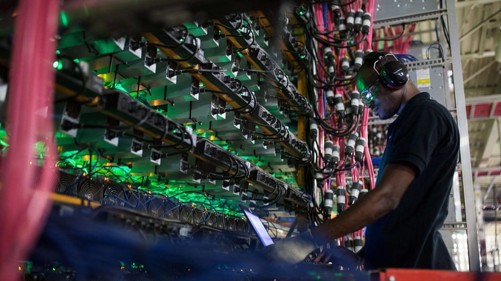 A technician monitors cryptocurrency mining rigs at a Bitfarms facility in Saint-Hyacinthe, Quebec, Canada | Representational image