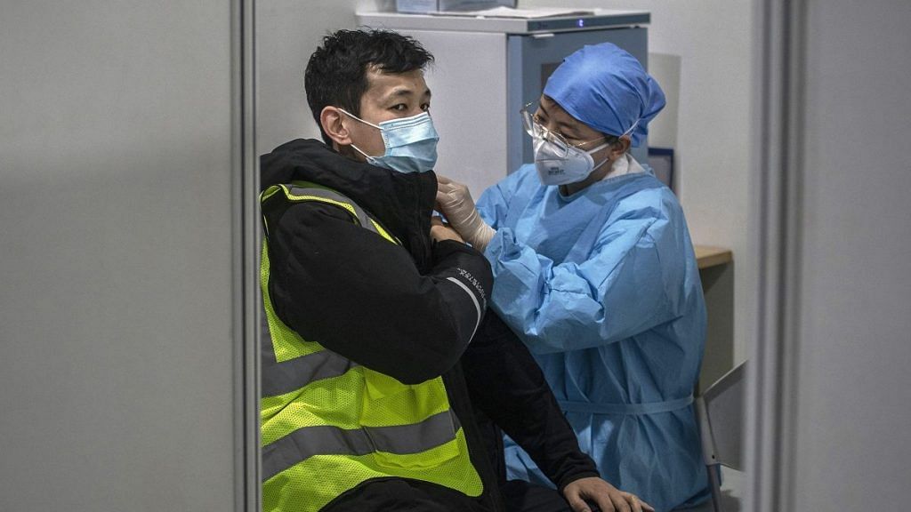 A Chinese health care worker gives a Covid-19 vaccine shot to a man at a mass vaccination center for Chaoyang District on 15 January 2021 in Beijing, China | Kevin Frayer | Getty Images via Bloomberg