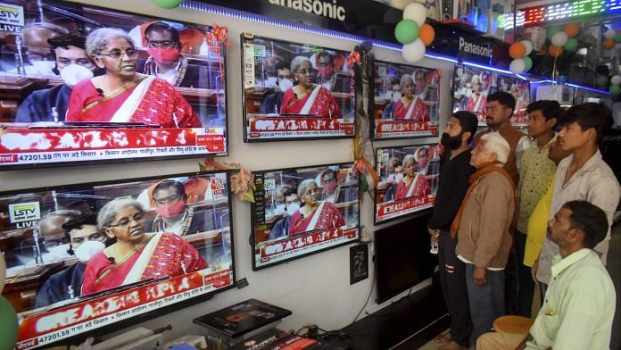 People watch Finance Minister Nirmala Sitharaman presenting the Union Budget at an electronics store in Prayagraj, on 1 February | PTI Photo