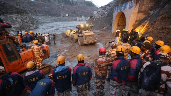 Rescue and relief workers stand near the damaged Rishi Ganga power project | Photo: Suraj Singh Bisht | ThePrint