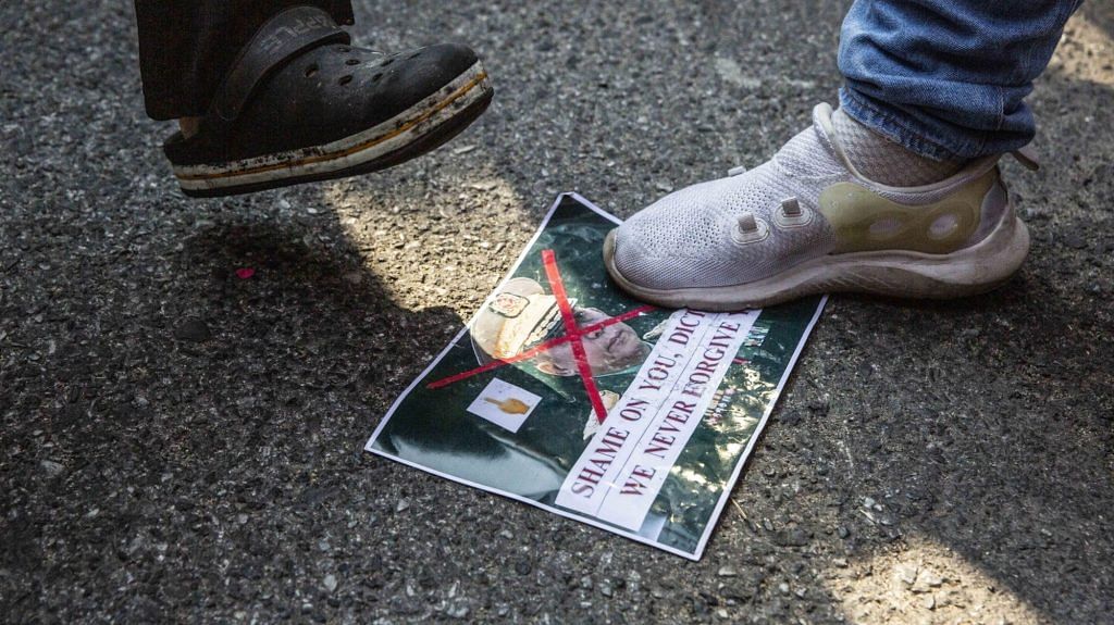 A demonstrator steps on an image of Army chief Min Aung Hlaing during a protest outside Myanmar Embassy in Bangkok, Thailand, on 1 Feb 2021