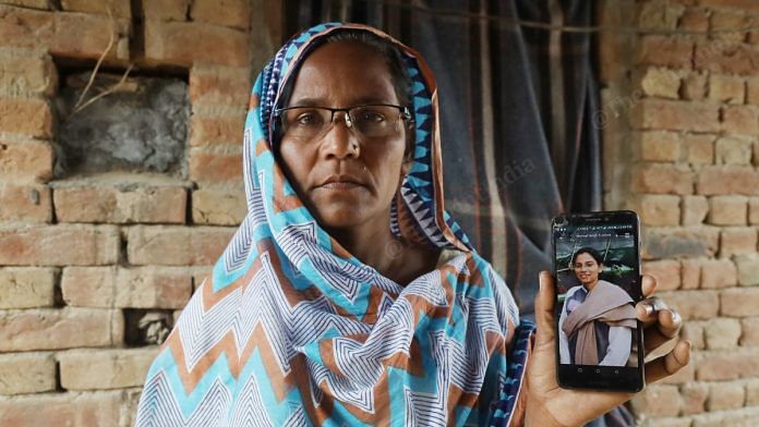 Swarnjit Kaur holds up a mobile phone with her activist daughter Nodeep Kaur's image at their home in Gandera village, Sri Muktsar Sahib district in Punjab | Photo: Manisha Mondal | ThePrint