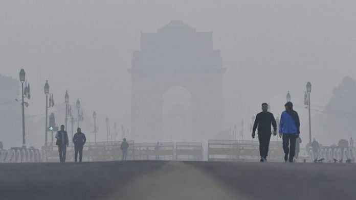 People walk past the India Gate monument shrouded in smog in New Delhi. (Representational image) | Anindito Mukherjee | Bloomberg