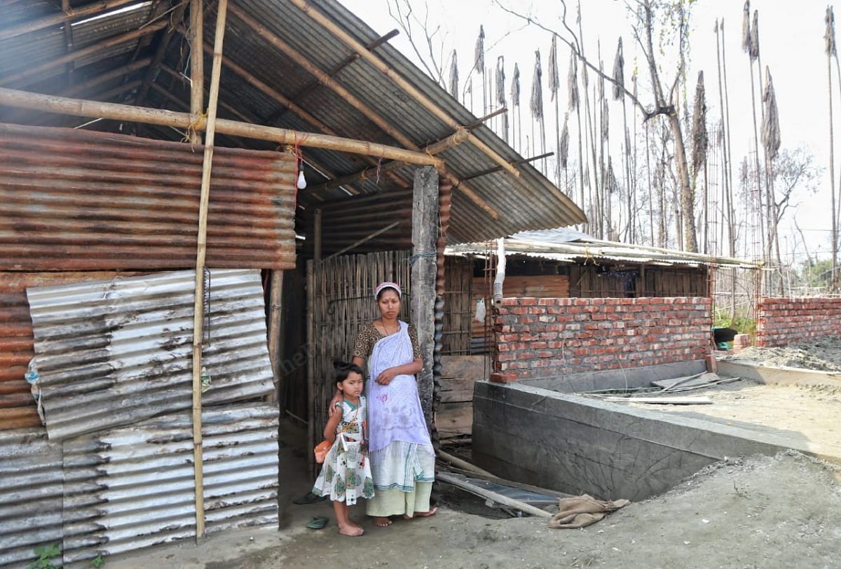 Nobabi and Tanushree stand outside their house that was made using tin. Nobabi laughs saying that only remain she has is the pillar she in leaning on | Photo: Manisha Mondal | ThePrint