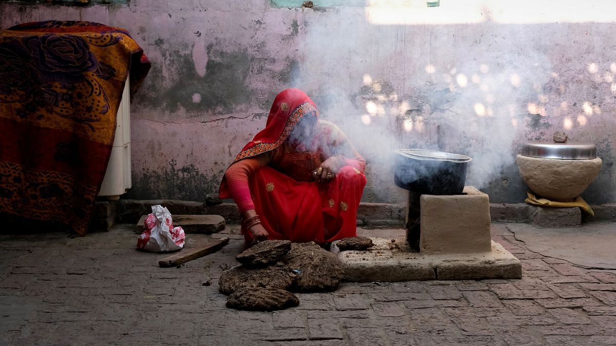A woman uses dung as a cooking fuel at her village home in Uttar Pradesh (Represenational Image) | Photographer T. Narayan | Bloomberg