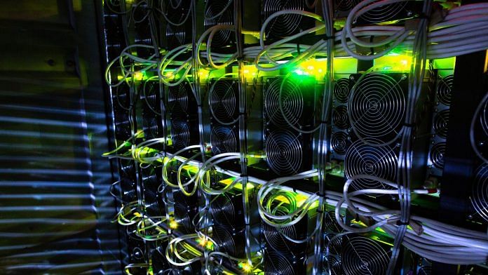 Illuminated application-specific integrated circuit (ASIC) mining devices and power units in a rack at the cryptocurrency mining farm | Andrey Rudakov | Bloomberg