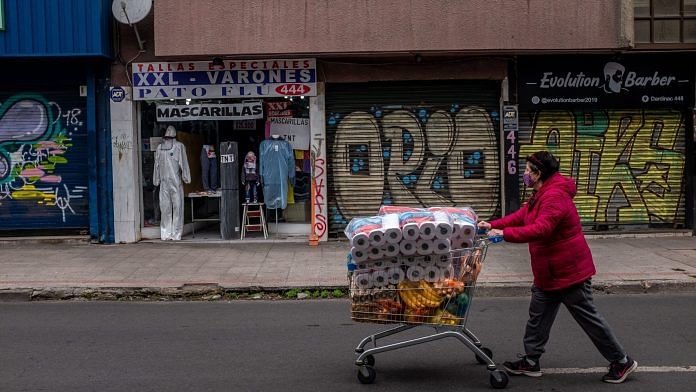 A shopper with toilet paper and groceries in Santiago, Chile | Bloomberg
