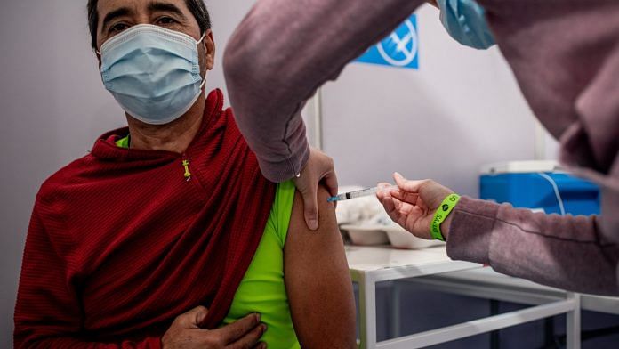 A healthcare worker administers a dose of the CanSino Covid-19 vaccine at a temporary clinic inside the Bicentenario Stadium in Santiago, Chile, on Monday, 29 March, 2021. | Photographer: Cristbal Olivares | Bloomberg