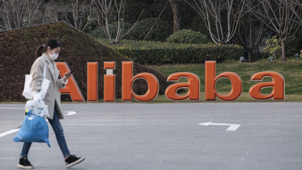 A pedestrian passes by a logo outside the Alibaba Group Holding Ltd. headquarters in Hangzhou, China