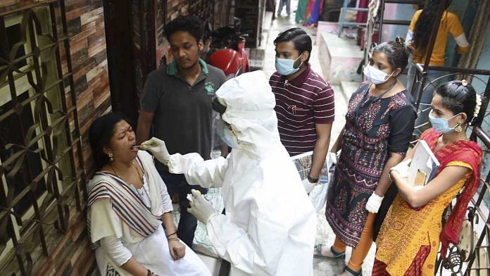 A health worker collects swab samples of residents of Dharavi during a door-to-door screening for Covid-19 in Mumbai, on 11 March 2021 | Kunal Patil | PTI