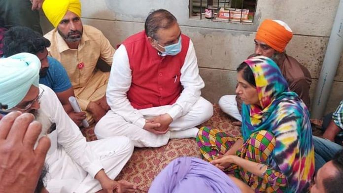 National Commission for Scheduled Castes Chairman Vijay Sampla (in red jacket) speaks to the family of two Dalit sisters who were murdered in Moga | Photo: Twitter/@vijaysamplabjp