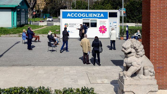 Visitors stand in line at a Covid-19 vaccination center in Rome, Italy | Photographer: Alessia Pierdomenico | Bloomberg
