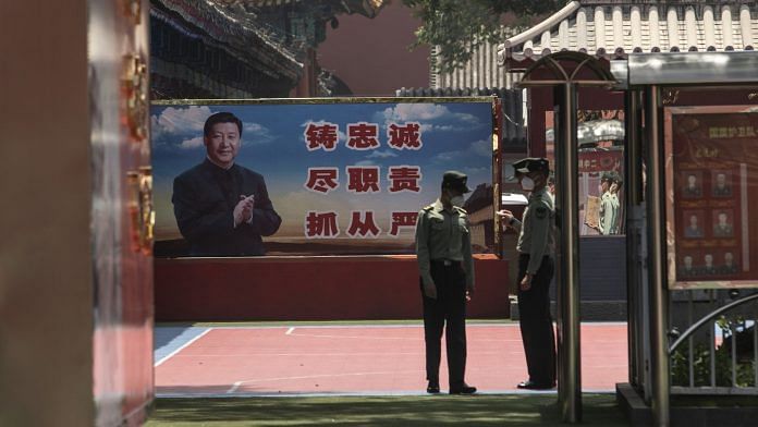 People's Liberation Army soldiers in front of a banner depicting Chinese president Xi Jinping near the Forbidden City in Beijing | Photo: Qilai Shen | Bloomberg File
