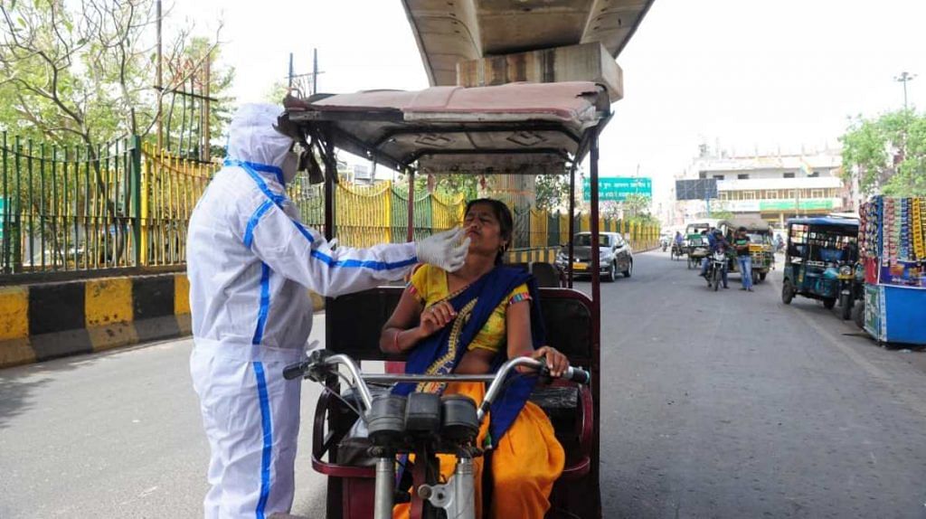 A health worker takes samples from an e-rickshaw driver for Covid test in Delhi-Noida border on 25 March 2021 | Suraj Singh Bisht | ThePrint