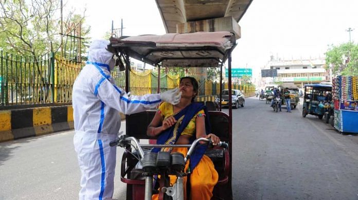 A health worker takes samples from an e-rickshaw driver for Covid test in Delhi-Noida border on 25 March 2021 | Suraj Singh Bisht | ThePrint