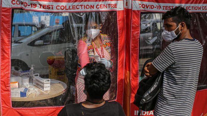 A health worker takes a swab at a Covid-19 testing site set up at the Goregaon NESCO jumbo Covid centre in Mumbai, on 27 April 2021 | Bloomberg