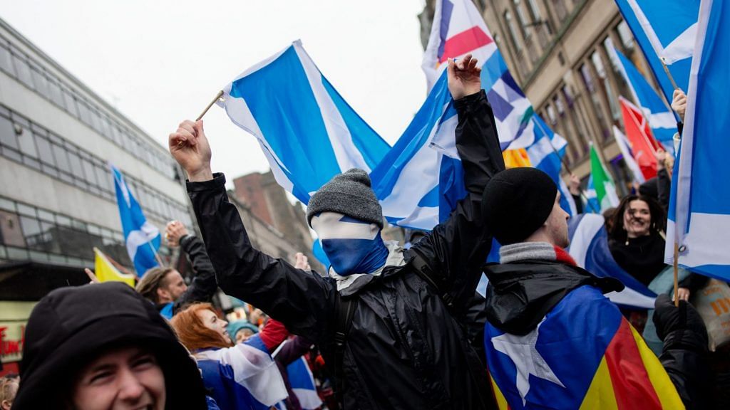 A demonstrator holds a Scottish national flag while marching during an All Under One Banner (AUOB) march for Scottish independence in Glasgow, Scotland on Saturday, Jan. 11, 2020. | Photographer: Emily Macinnes | Bloomberg