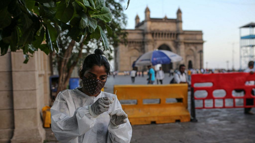 A healthcare worker prepares to administer a rapid antigen test near the Gateway of India monument in Mumbai | Photographer: Dhiraj Singh | Bloomberg