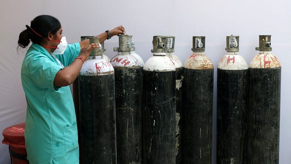 A health worker checks oxygen cylinders at a makeshift Covid-19 quarantine facility set up in a banquet hall in New Delhi | Representational image | Bloomberg