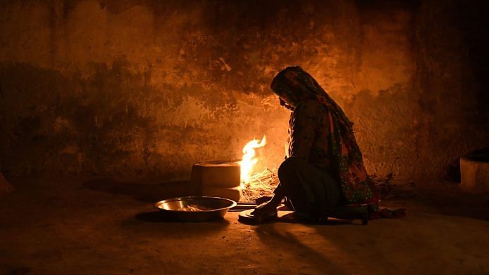A woman prepares a fire for a clay oven while cooking in her home in Dhamaka village, Haryana (Representational image) | Photographer: Anindito Mukherjee | Bloomberg