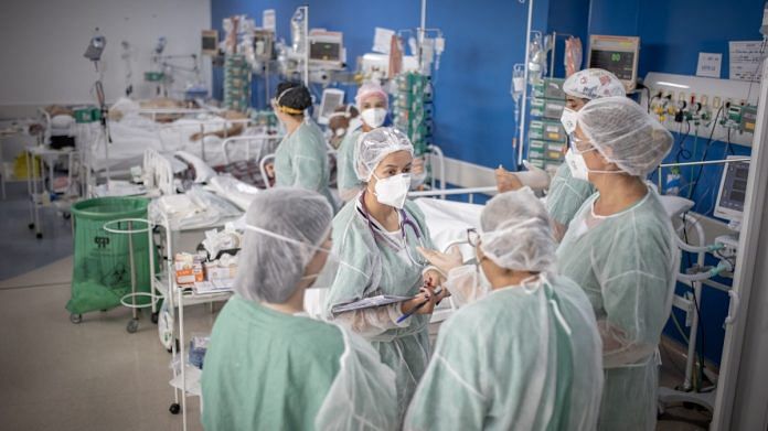 Healthcare workers treat patients inside a Covid ICU ward at a field hospital in Sao Paulo, Brazil, on March 19 2021 | Photographer: Jonne Roriz | Bloomberg