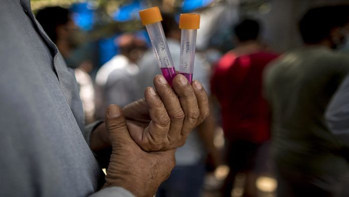 A man waits with his sample at a Covid-19 testing station in New Delhi, on 30 April 2021 | Photographer: Anindito Mukherjee | Bloomberg
