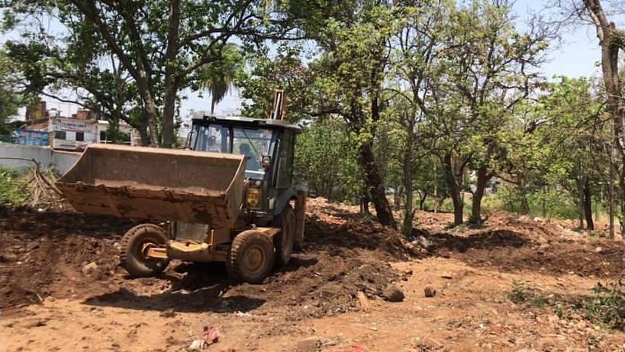 A JCB digs the ground for a grave at Bhopal’s Jahangirabad graveyard | Taran Deol | ThePrint