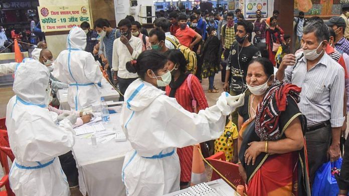 Health workers conduct Covid-19 testing of passengers arriving from Maharashtra at Patna Railway Station, as coronavirus cases surge across the country, in Patna, on 13 April 2021 | PTI