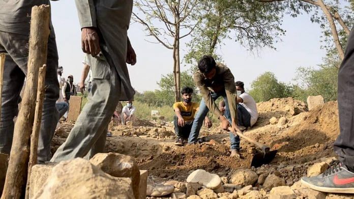 Staff at Delhi's Qabristan Ahle Islam dig a grave for a Covid patient Thursday | Tenzin Zompa | ThePrint