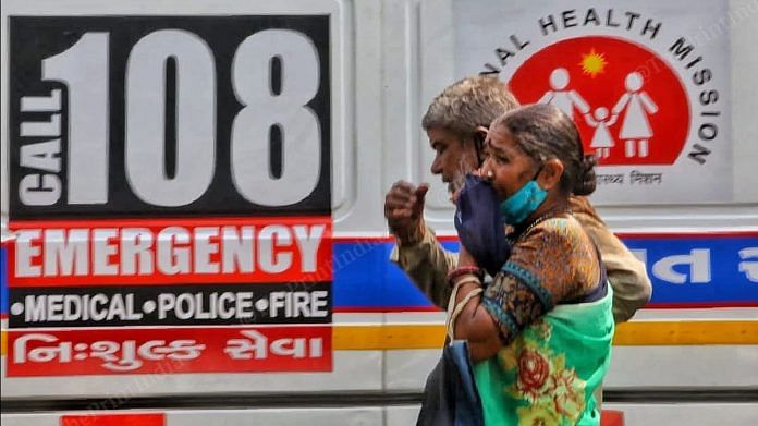 A grieving couple walks past the queue of ambulances outside the Ahmedabad Civil Hospital | Photo: Praveen Jain | ThePrint