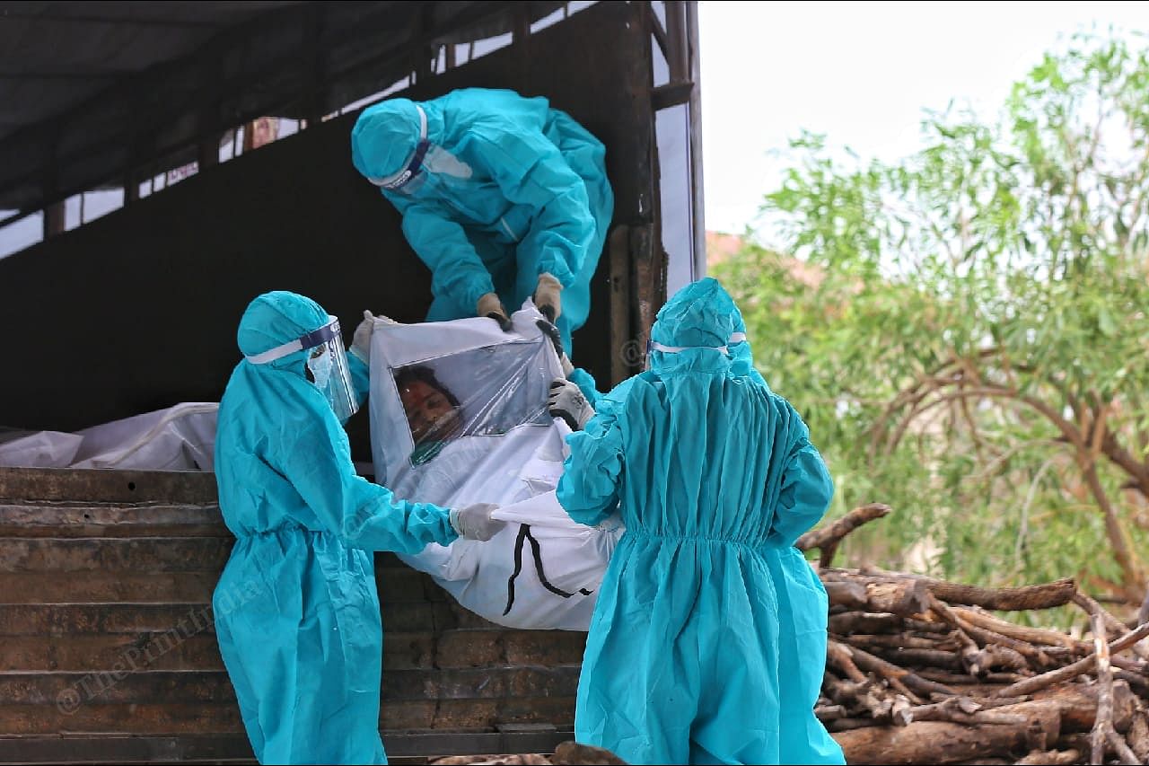 Municipal worker unloading the dead body of a Covid patient at Cremenation ground | Photo: Suraj Singh Bisht | ThePrint