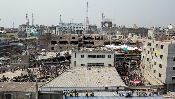 People stand and watch as rescue workers search for victims amongst the debris of the collapsed Rana Plaza building in Dhaka, Bangladesh, on 26 April 2013 | Photo: Jeff Holt | Bloomberg