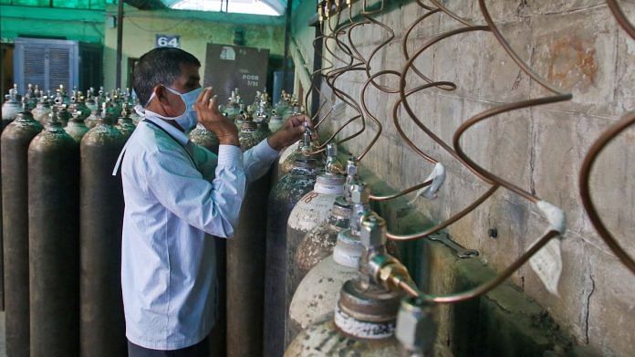 A worker fit medical oxygen cylinders from an Oxygen plant, amid a surge in coronavirus cases, at Sawai Mansingh hospital in Jaipur, on 26 April 2021 | PTI