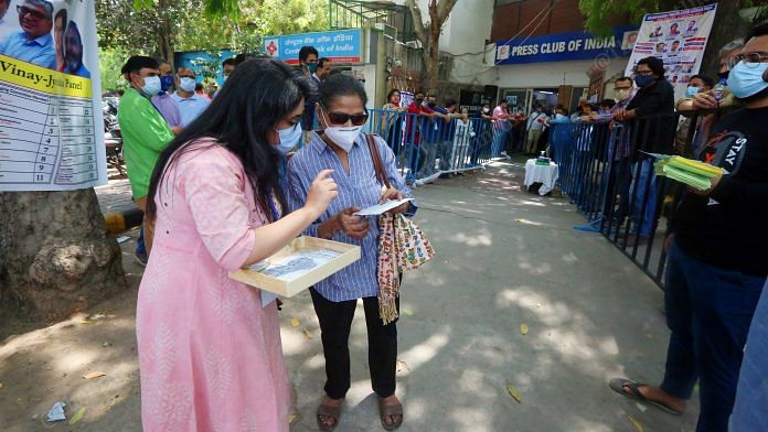 Journalists look at their voting slips outside the Press Club of India | Photo: Praveen Jain | ThePrint
