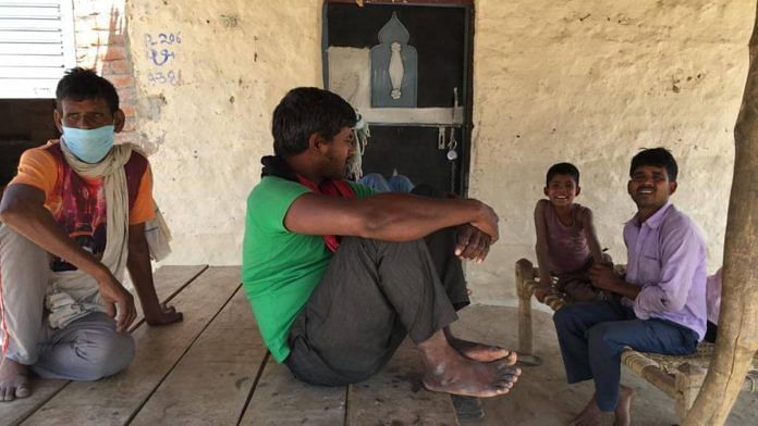 Inderpal Pasi - in orange shirt - a farm labour in Pratappur village, discusses the Covid situation in his area, with his friends Sunday | Moushumi Das Gupta | ThePrint