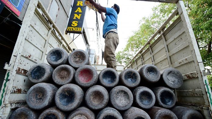 A worker loads empty cylinders of medical oxygen in New Delhi, on 21 April 2021 | PTI