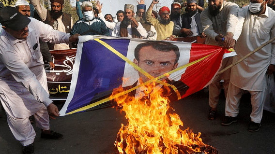 Tehreek-i-Labaik Pakistan agitators burn a photo of French President Emmanuel Macron in protest against blasphemous caricatures published in France in 2020 | @SabahKashmiri | Twitter