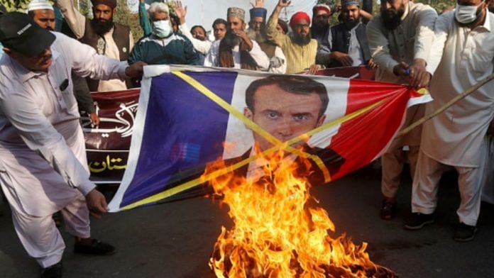 Tehreek-e-Labbaik Pakistan agitators burn a photo of French President Emmanuel Macron in protest against blasphemous caricatures published in France in 2020 | @SabahKashmiri | Twitter