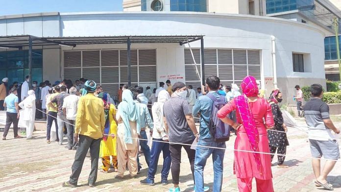 People queue at the trauma centre at PGIMS, Rohtak, to get samples for their Covid test collected. The hospital is facing a manpower crunch since many doctors and healthcare workers have tested positive for Covid | Urjita Bhardwaj | ThePrint