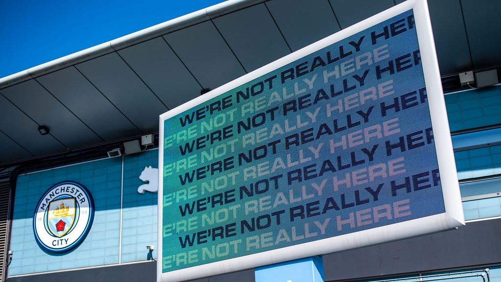 A sign reading 'We're Not Really Here' on display outside the City of Manchester Stadium, also known as the Eithad Stadium, the home ground of Manchester City Football Club, in Manchester on 19 April 2021