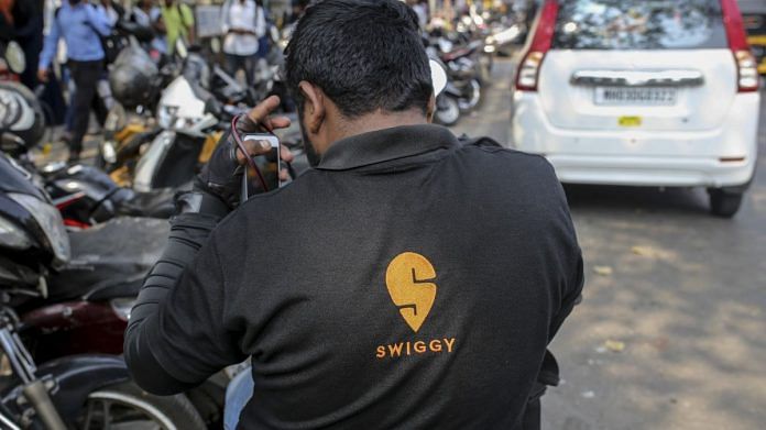 A food delivery rider for Swiggy sits on a motorcycle in Mumbai, on February 2020 | Photographer: Dhiraj Singh | Bloomberg