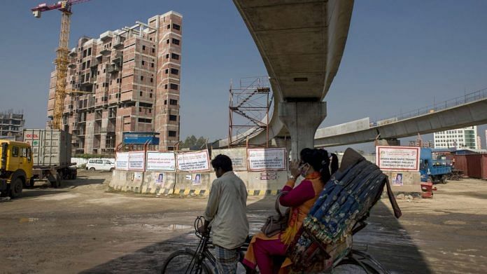 A rickshaw travels past an under construction elevated line for the Dhaka Mass Rapid Transit Co. metro in Diabari, Dhaka, Bangladesh | Photographer: Ismail Ferdous | Bloomberg