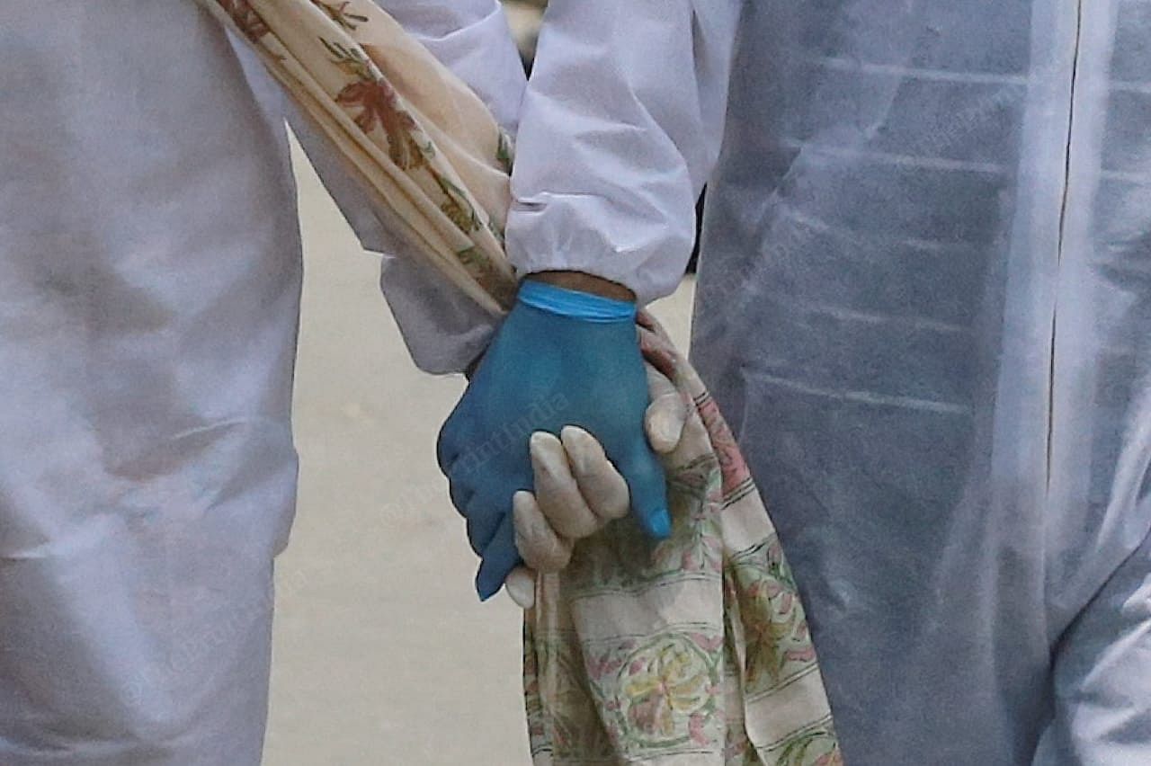 A kid, who lost his mother mother to covid -19, walks inside the mortuary holding his aunt's hand | Manisha Mondal | ThePrint